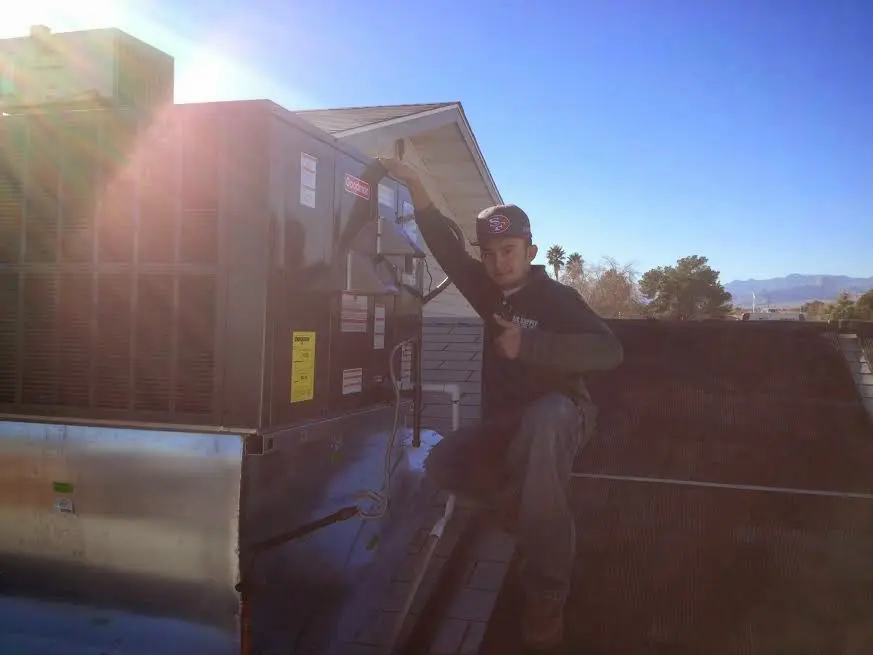 HVAC technician performing AC Tune-Up on a rooftop unit in Eagan